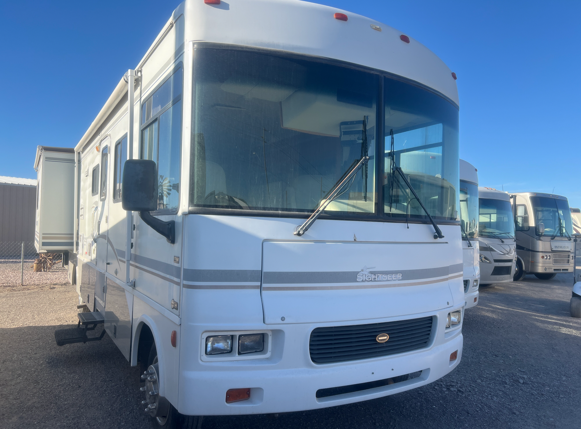 A white rv is parked in a parking lot.