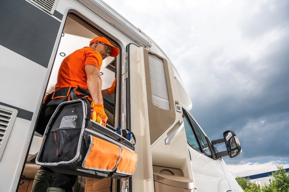 A Man Is Standing In The Doorway Of A Rv Holding A Tool Bag