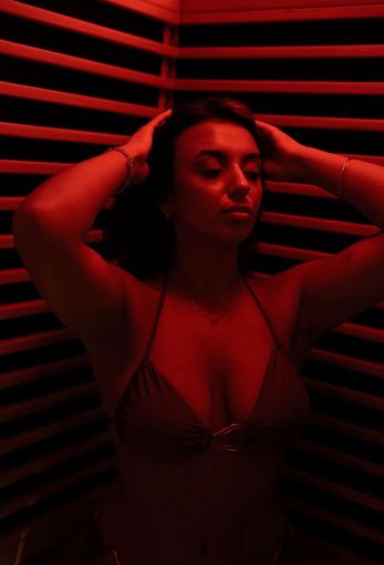 Silhouette of a person with an arm raised. Illuminated in red light, possibly smoke.