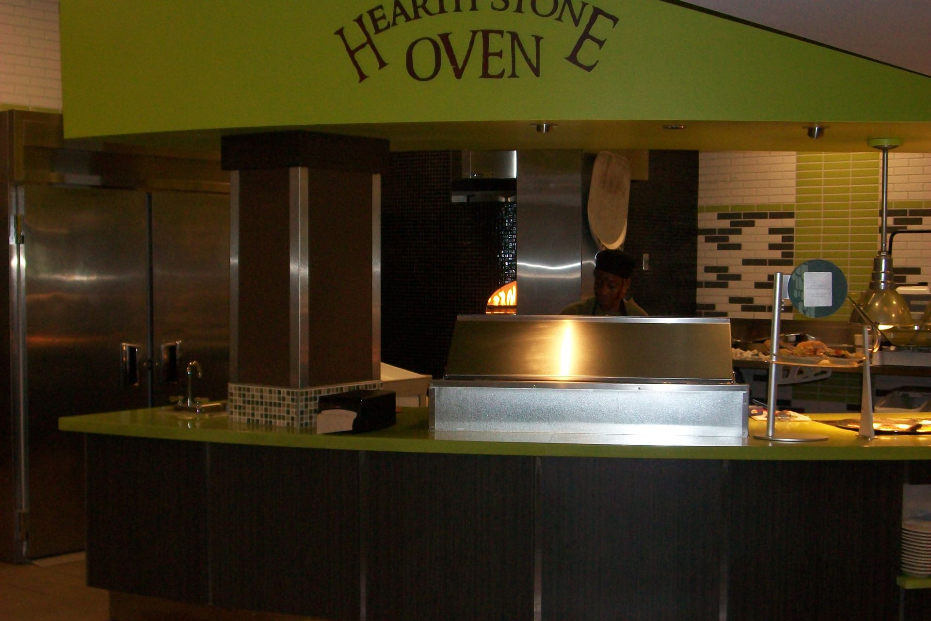 A green-accented pizza station with a 