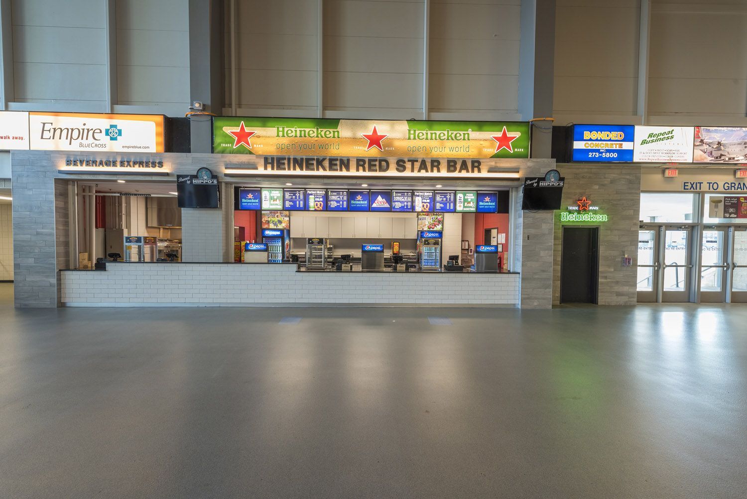 Heineken Red Star Bar concession stand inside a large, open indoor venue with a grey floor and light walls.