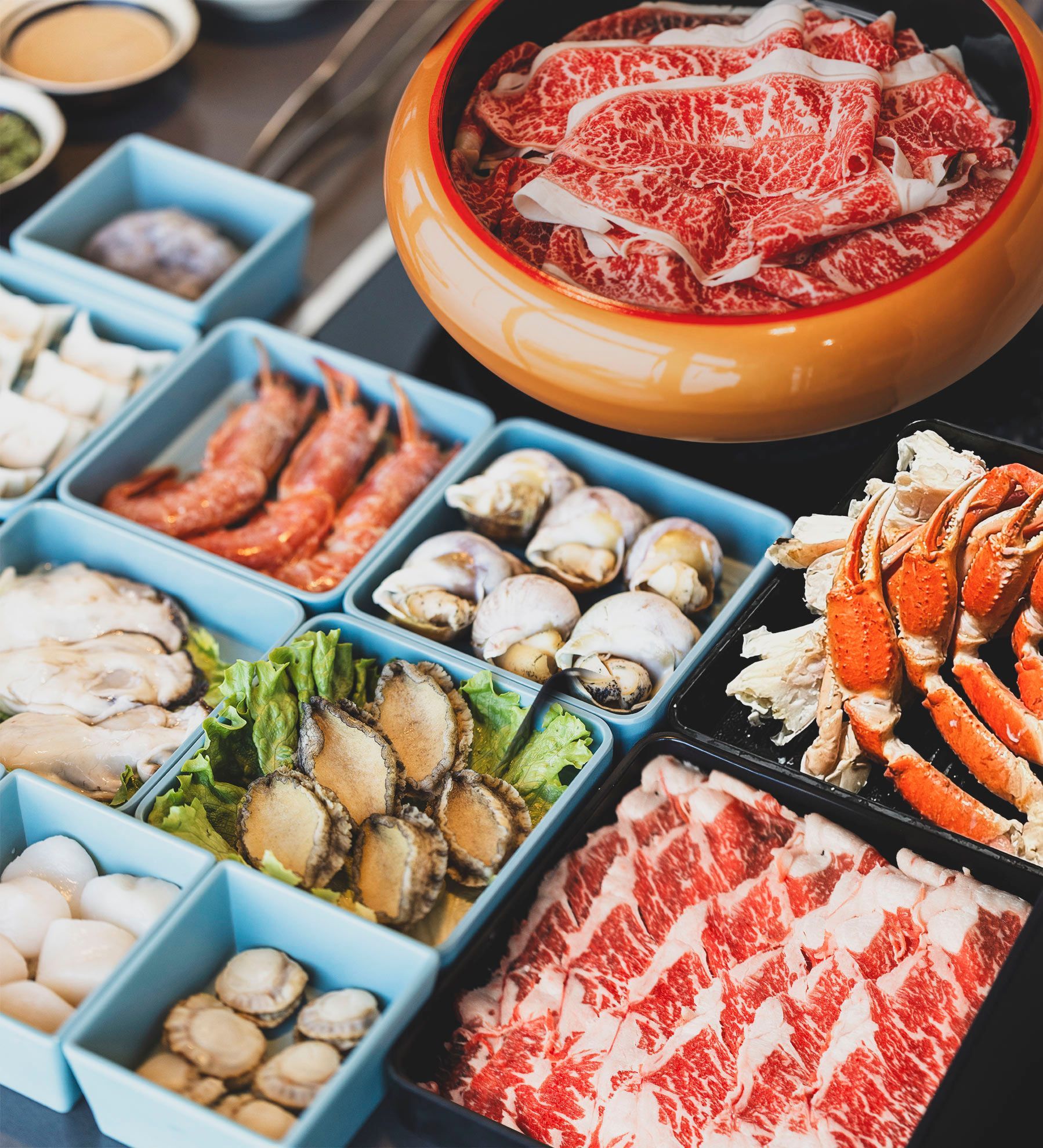 A table topped with a variety of meats and seafood