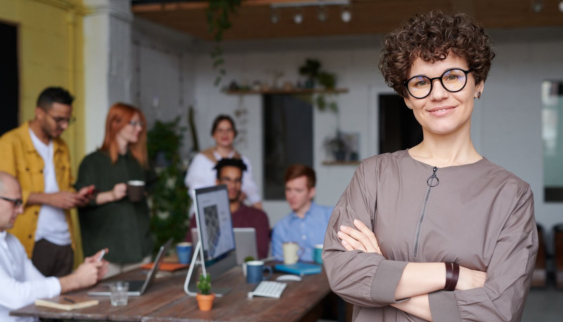 This is an image illustrating the comparison between NetSuite and Intacct. It features a woman with her coworkers behind her.