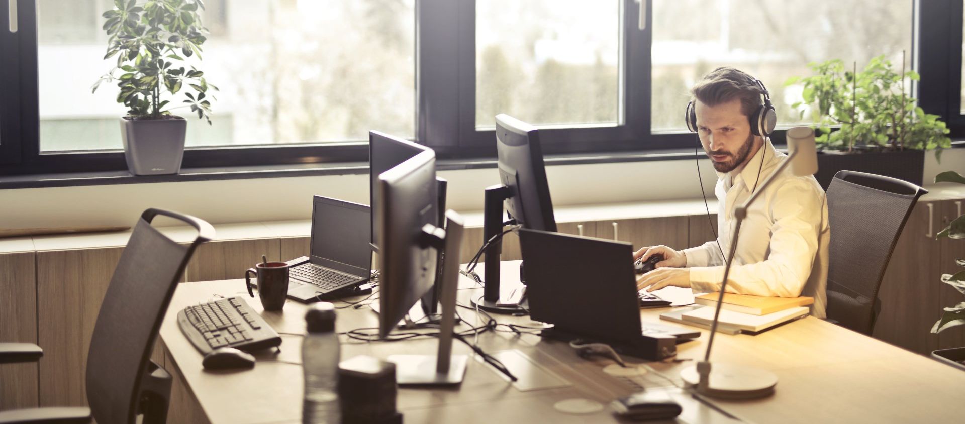 This is an image that illustrates automated financial processes. It features a man typing on a computer in an office.