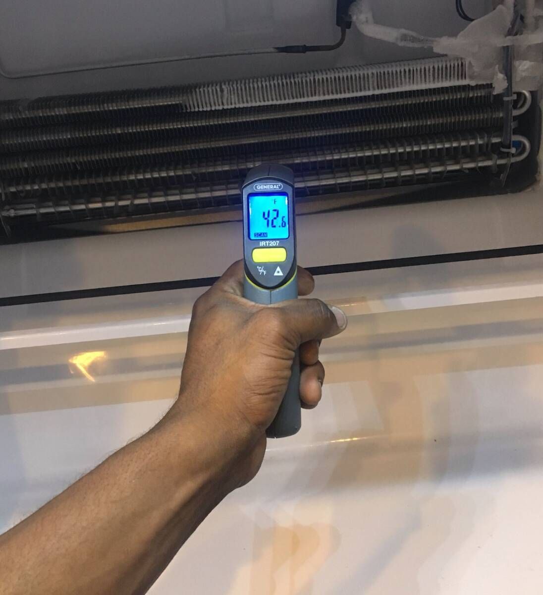 a person is holding a thermometer that reads 42.1