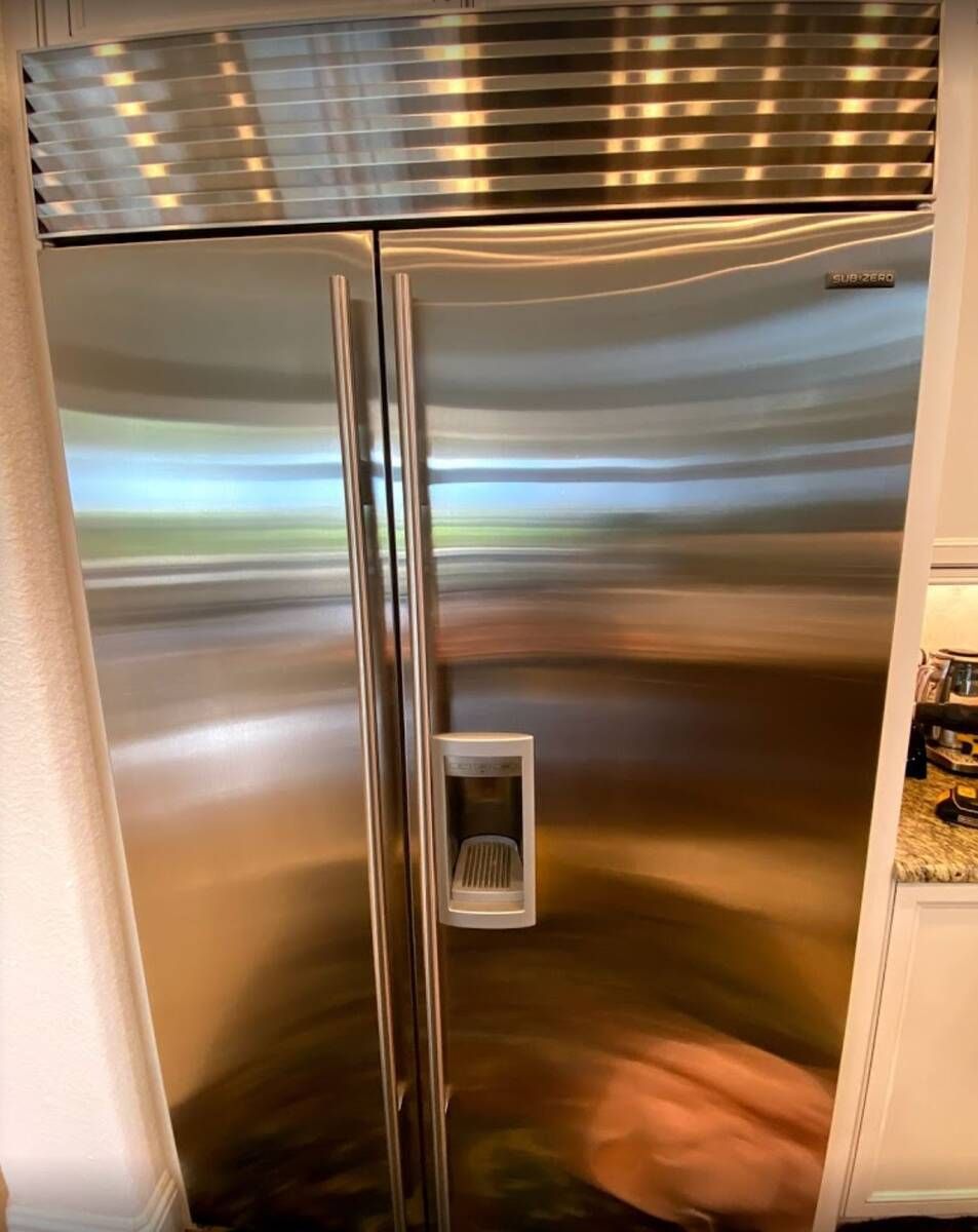 a stainless steel refrigerator is sitting in a kitchen .