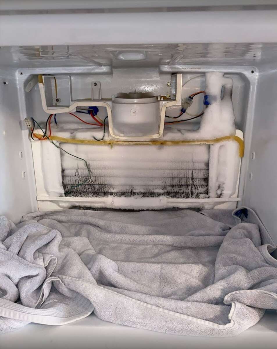 the inside of a refrigerator with a towel on the floor
