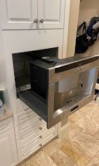 a microwave oven is sitting inside of a cabinet in a kitchen .