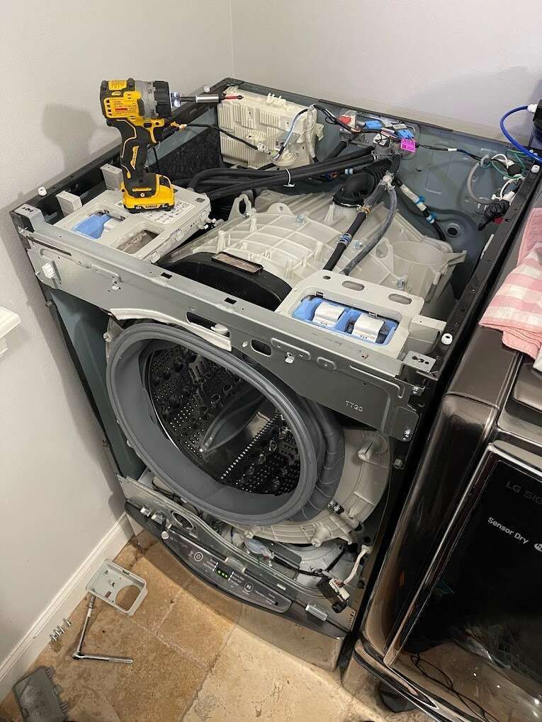 a washer and dryer are being repaired in a laundry room .