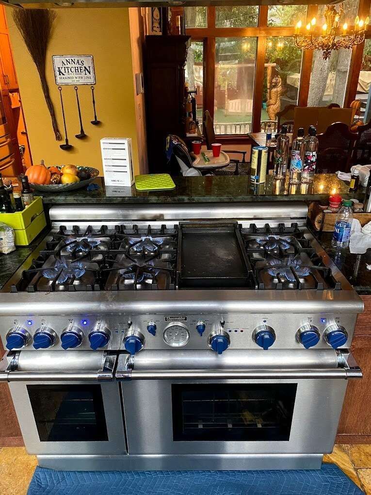 a stainless steel stove top oven is sitting on a blue rug in a kitchen .