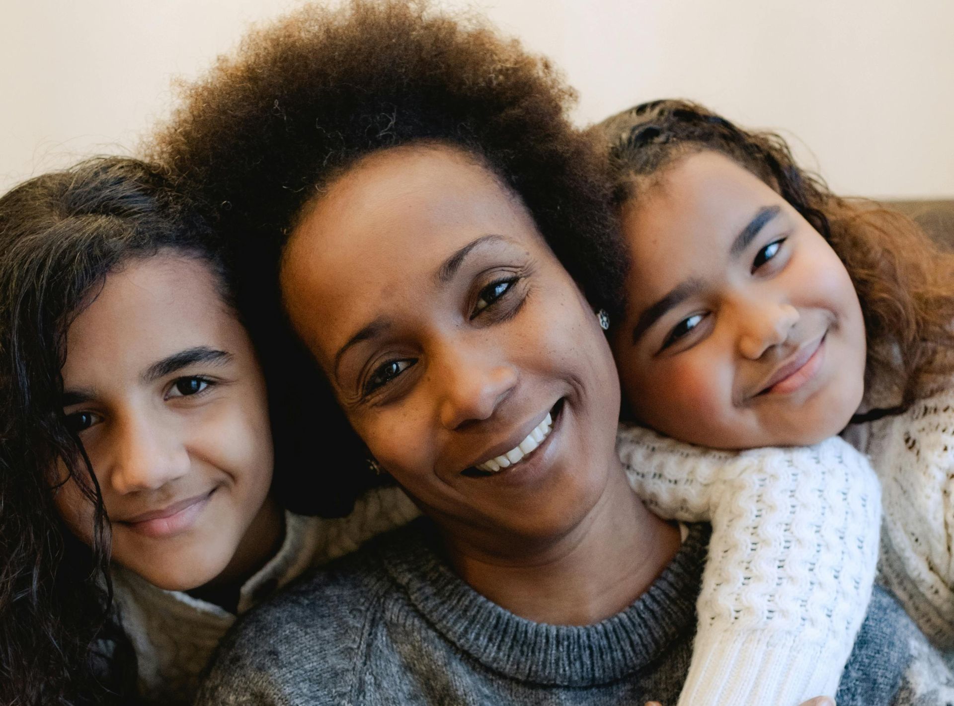 An adult female with two smiling girls