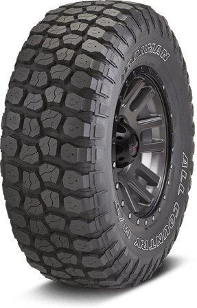 Black off-road tire with deep tread and rugged wheel rim on a white background