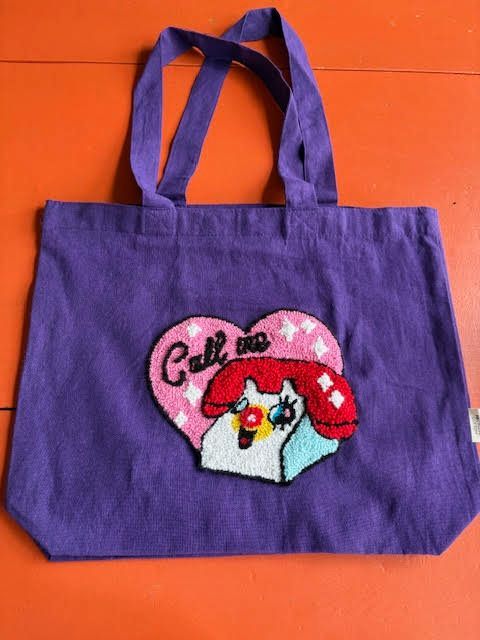 Paarse draagtas met een patch van een cartoontelefoon met de tekst 