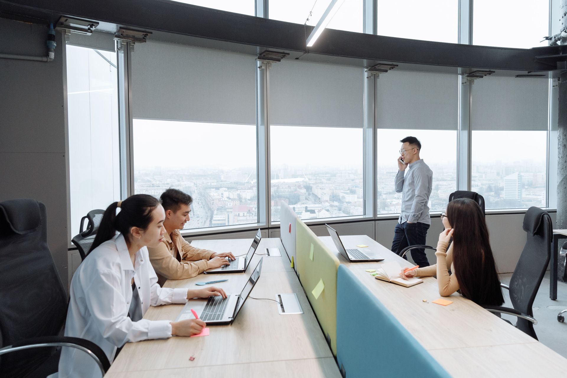 Business meeting in a bright conference room with laptops and a city view through large windows
