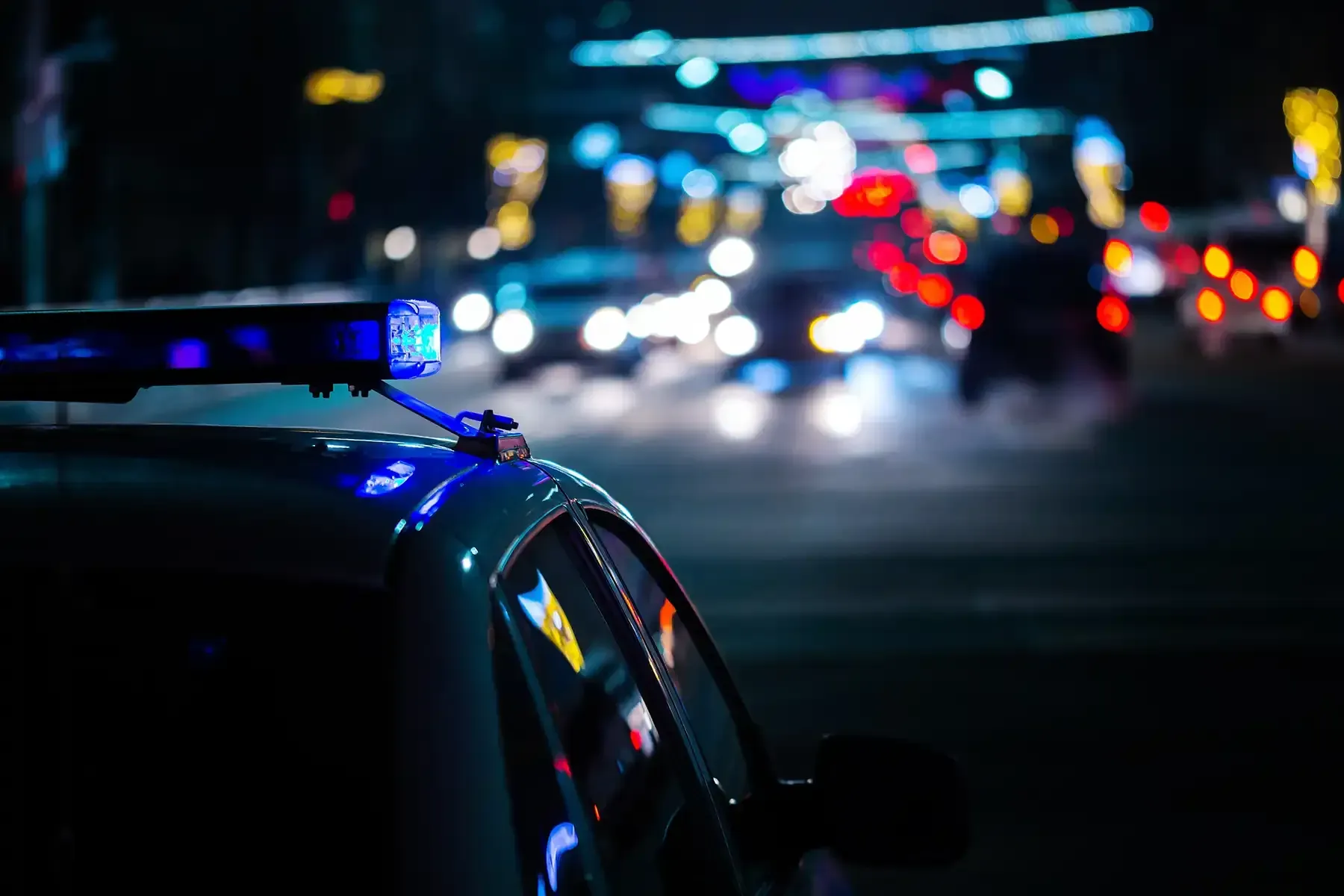 Police car with flashing lights on a dark city street at night