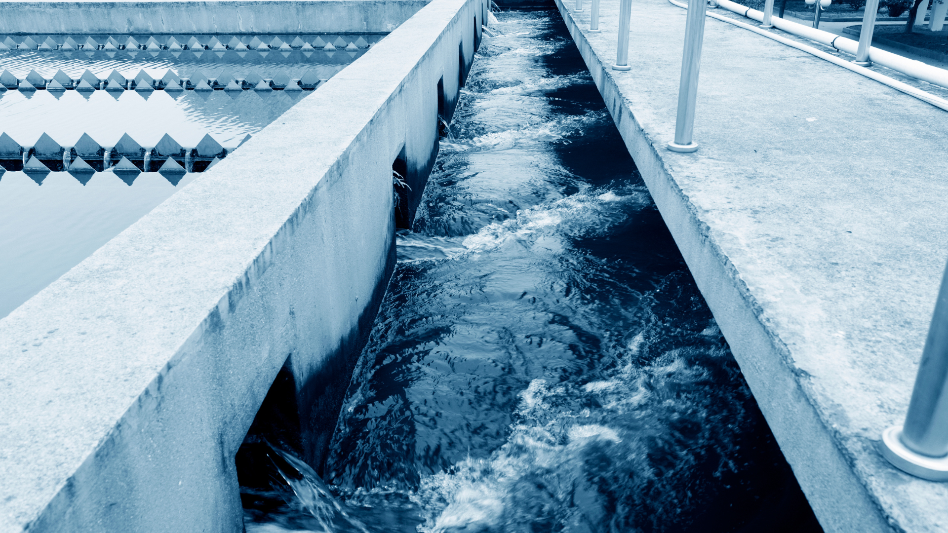 Agua que fluye a través de canales de hormigón en una planta de tratamiento de aguas residuales.
