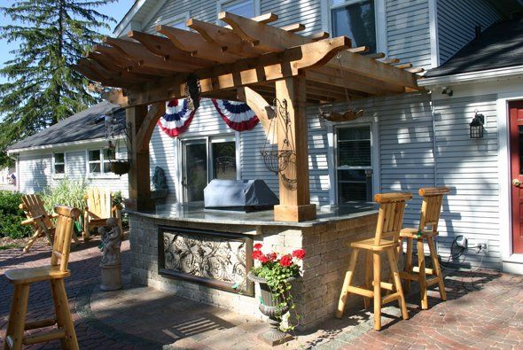 Nice outdoor kitchen with seats around it — Clarkston, MI — Lowries Landscape Inc