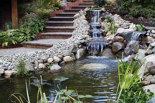 Stone steps next to waterfalls and pond — Clarkston, MI — Lowries Landscape Inc