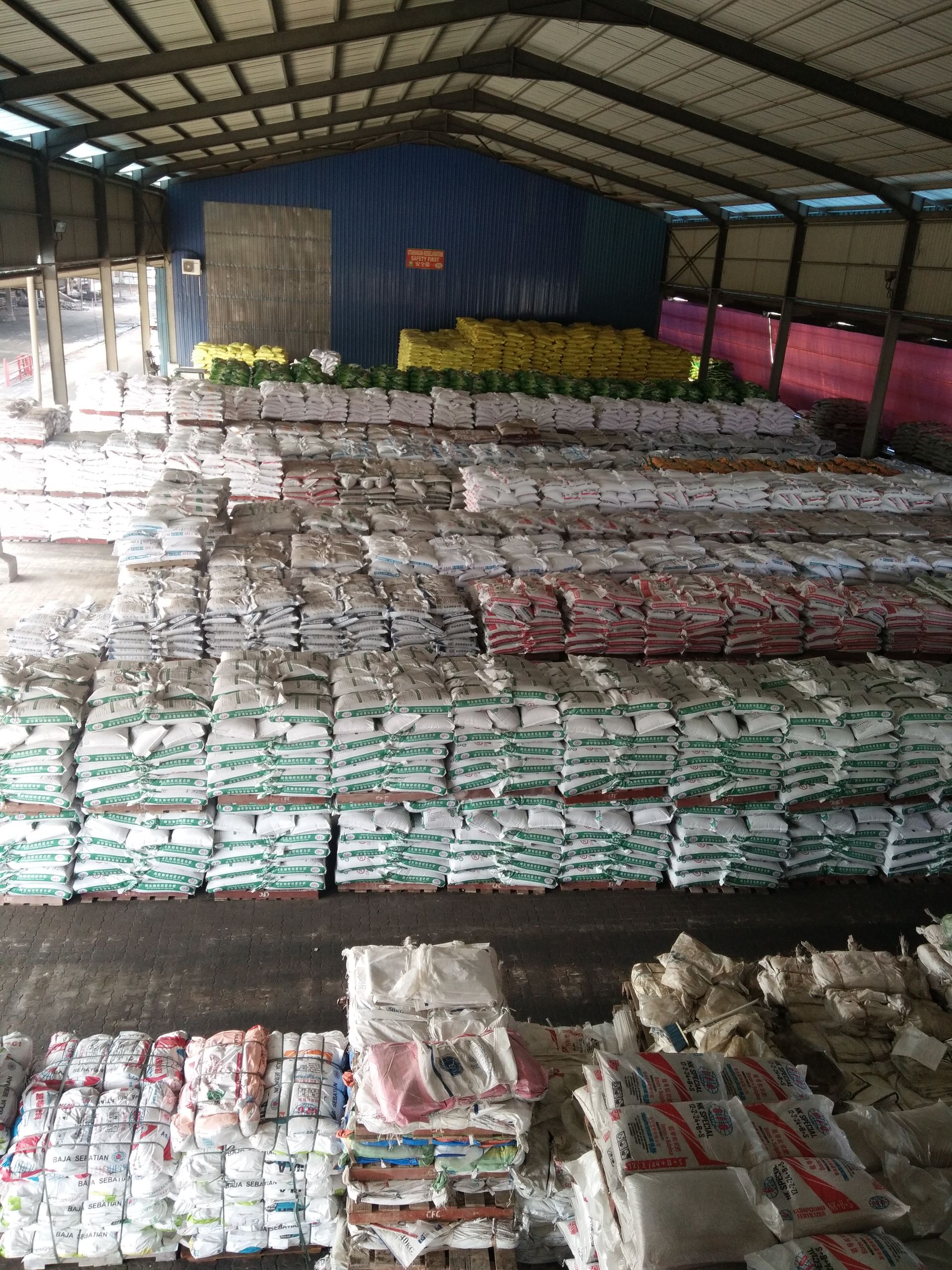 Sebuah gudang besar yang dipenuhi dengan banyak beg makanan.