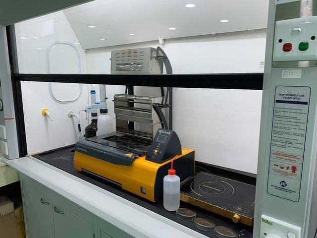 Sebuah mesin kuning sedang duduk di atas kaunter dalam makmal.