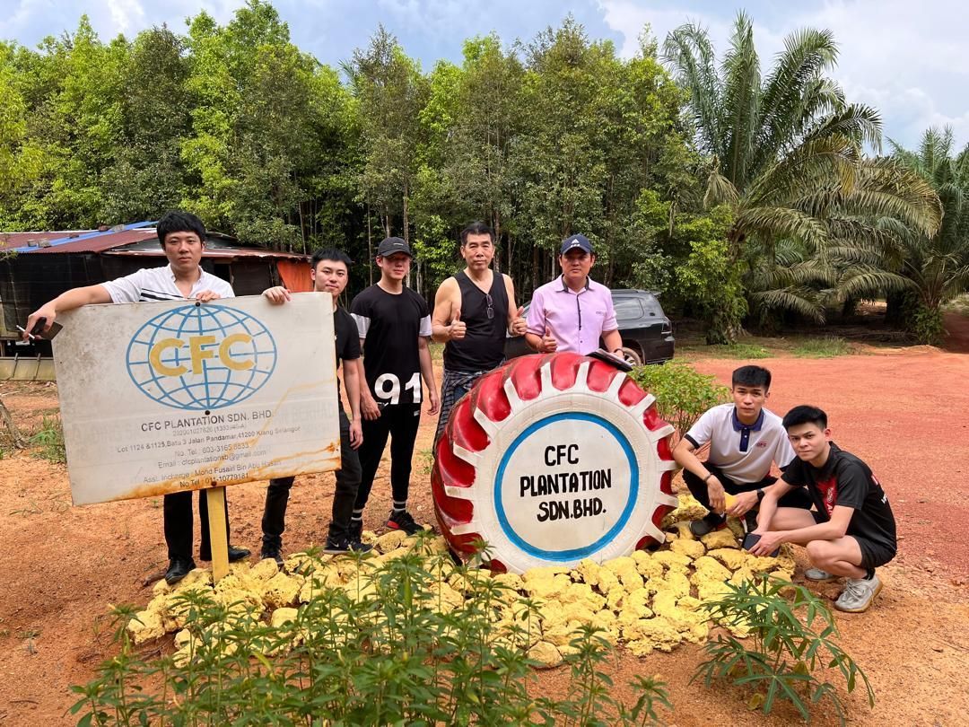 A group of young men are posing for a picture in front of a large drum.