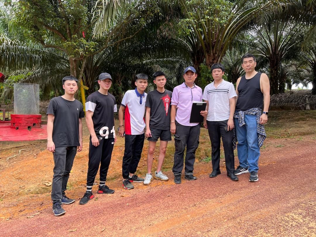 A group of young men are standing next to each other on a dirt road.