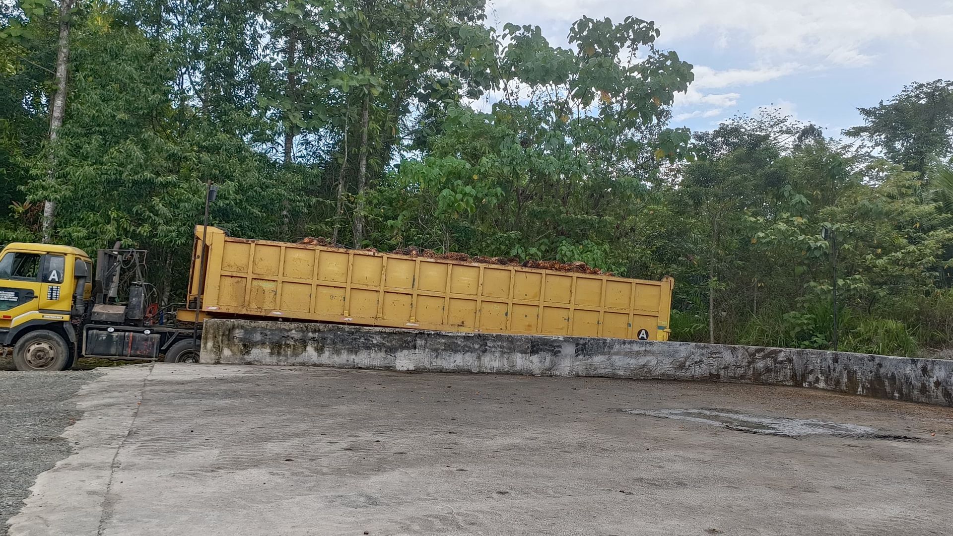 A yellow dump truck is parked in a parking lot.