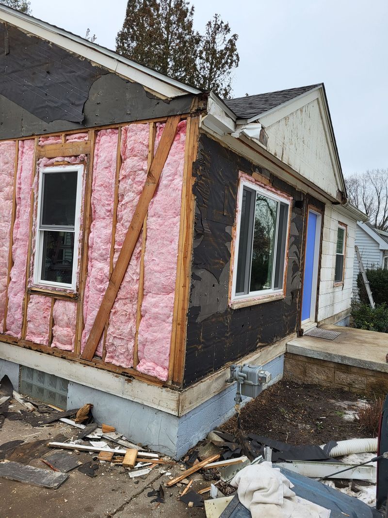 House exterior under construction, with exposed insulation and windows.