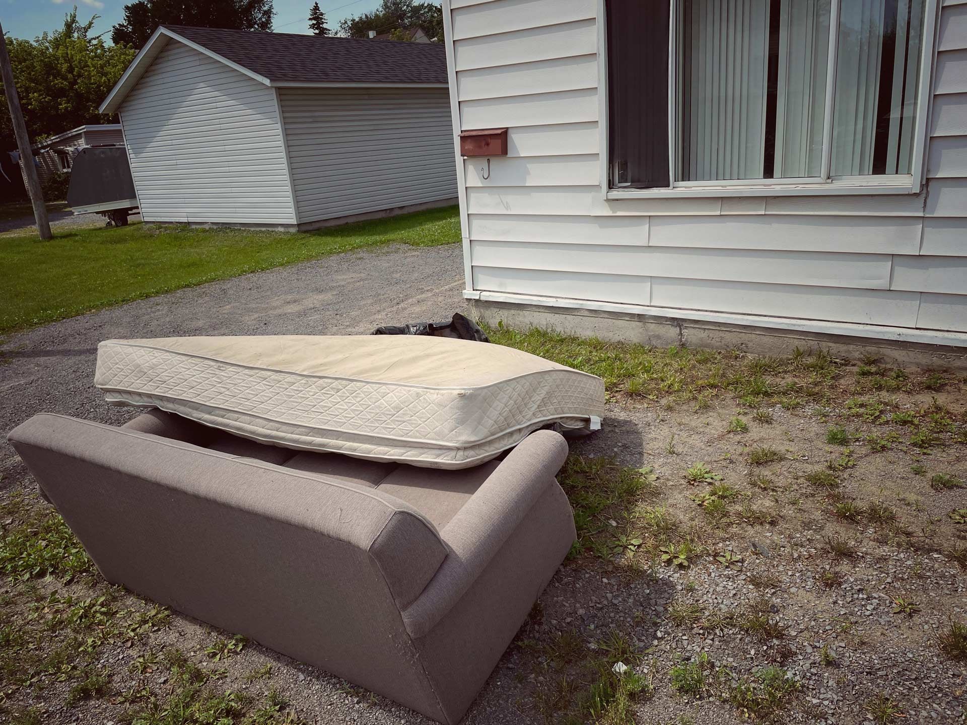 Old Mattress and Sofa in Front Yard