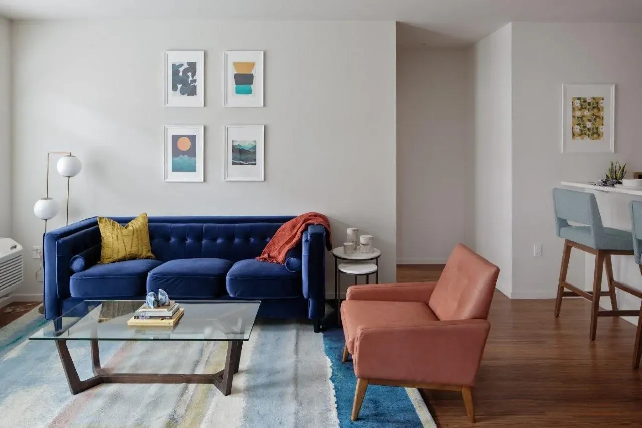 Modern living room with a blue sofa, armchair, and coffee table.