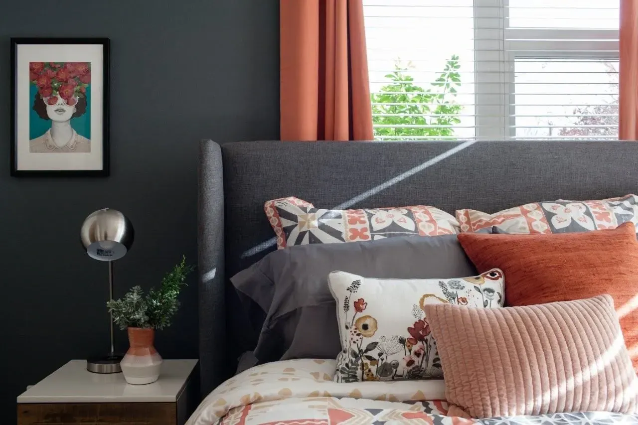 Bedroom with a king-sized bed, accent pillows, and a framed artwork.