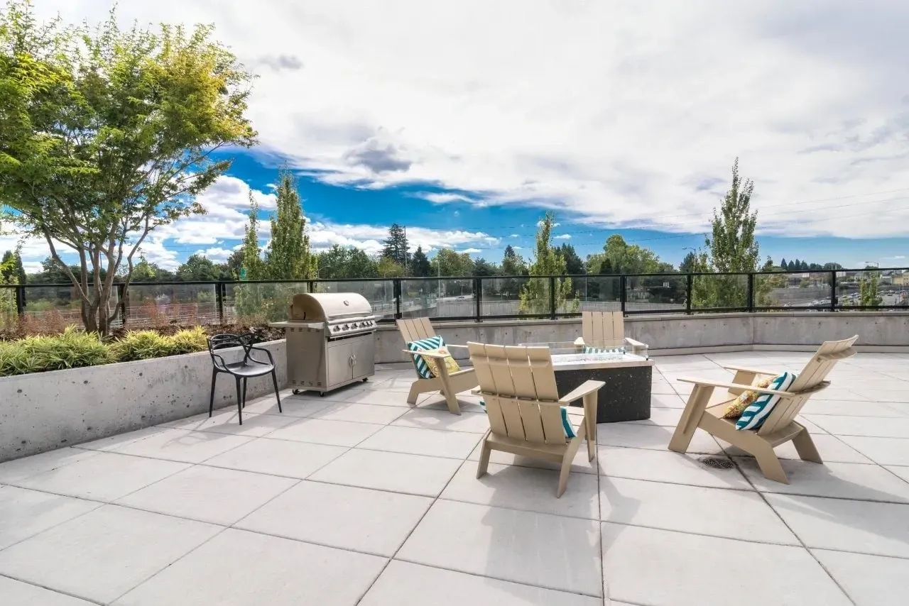 Rooftop patio with grill, fire pit, and seating area.