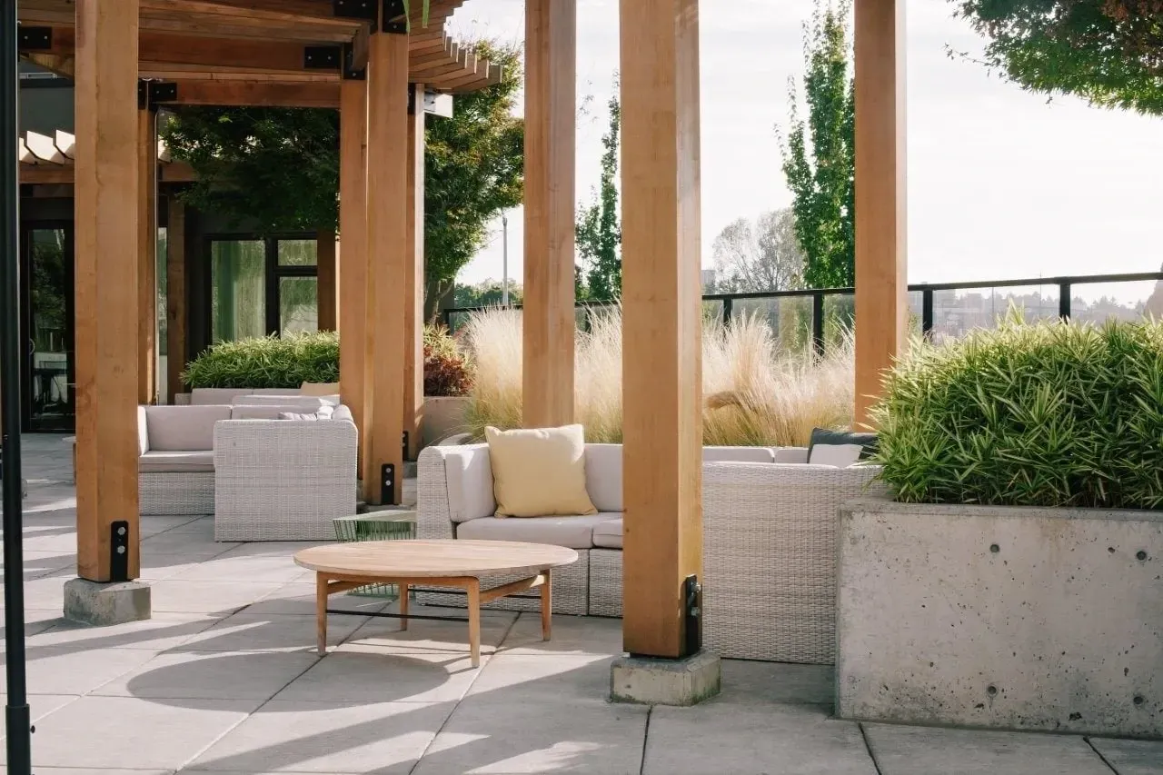 Outdoor lounge area with modern seating and wooden pergola.