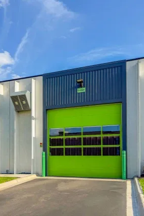 storage facility entrance, tall building with green garage door