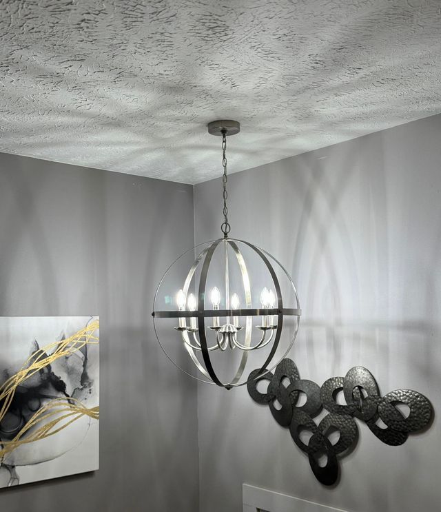 Modern ceiling light above abstract wall art in a gray room