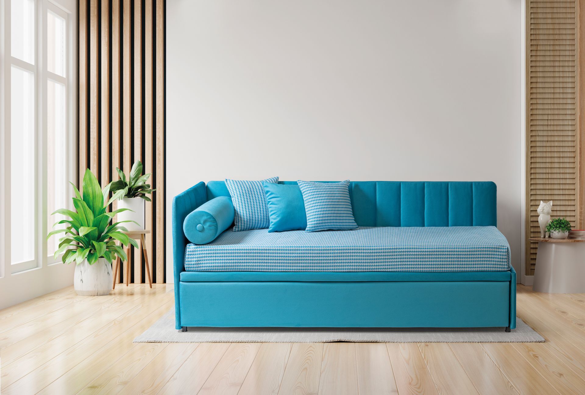 Un divano letto blu è posizionato nel soggiorno, accanto a una finestra.