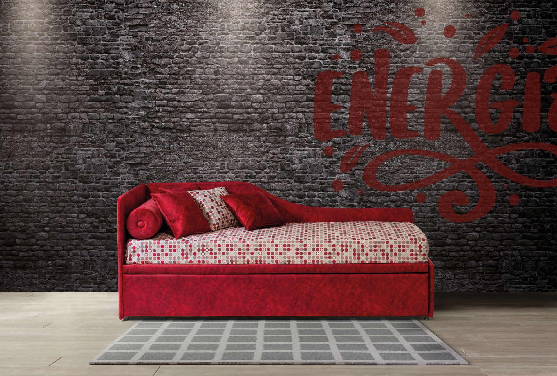 Un letto rosso è appoggiato di fronte a un muro di mattoni.
