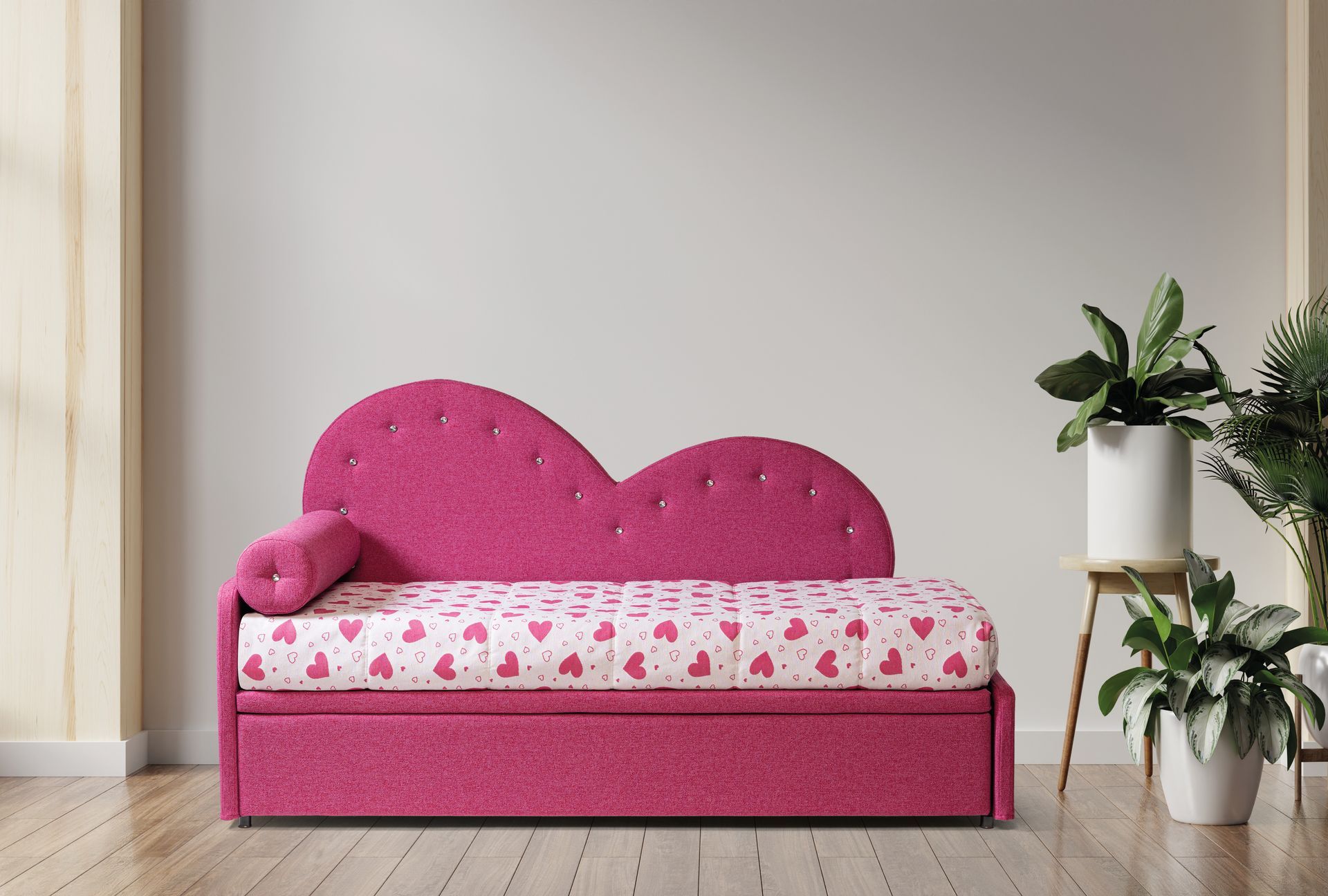 Un divano rosa con la testiera a forma di cuore si trova in una stanza con delle piante.