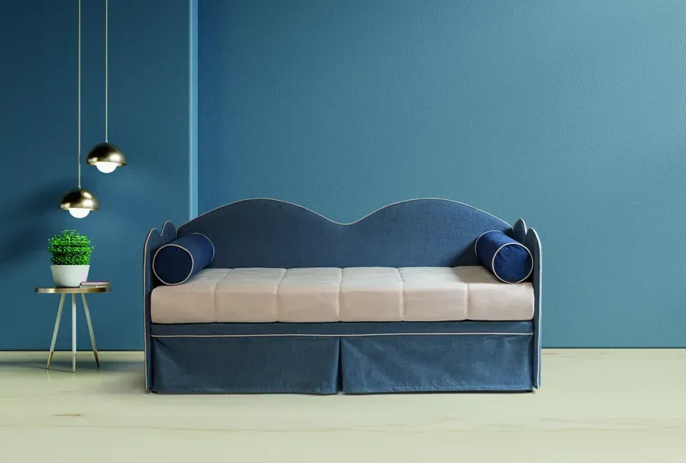 Un divano blu è posizionato in una stanza blu accanto a un tavolo.