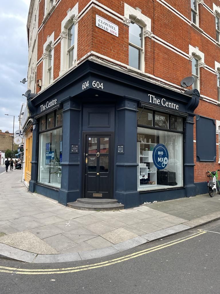 Corner shop with a navy blue facade, windows, and door.