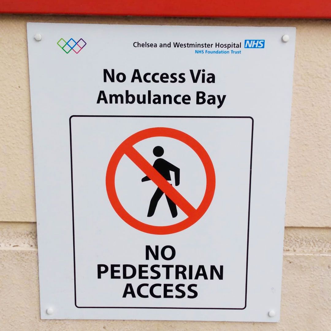 Sign: No pedestrian access via ambulance bay. Red circle with a crossed-out person symbol.