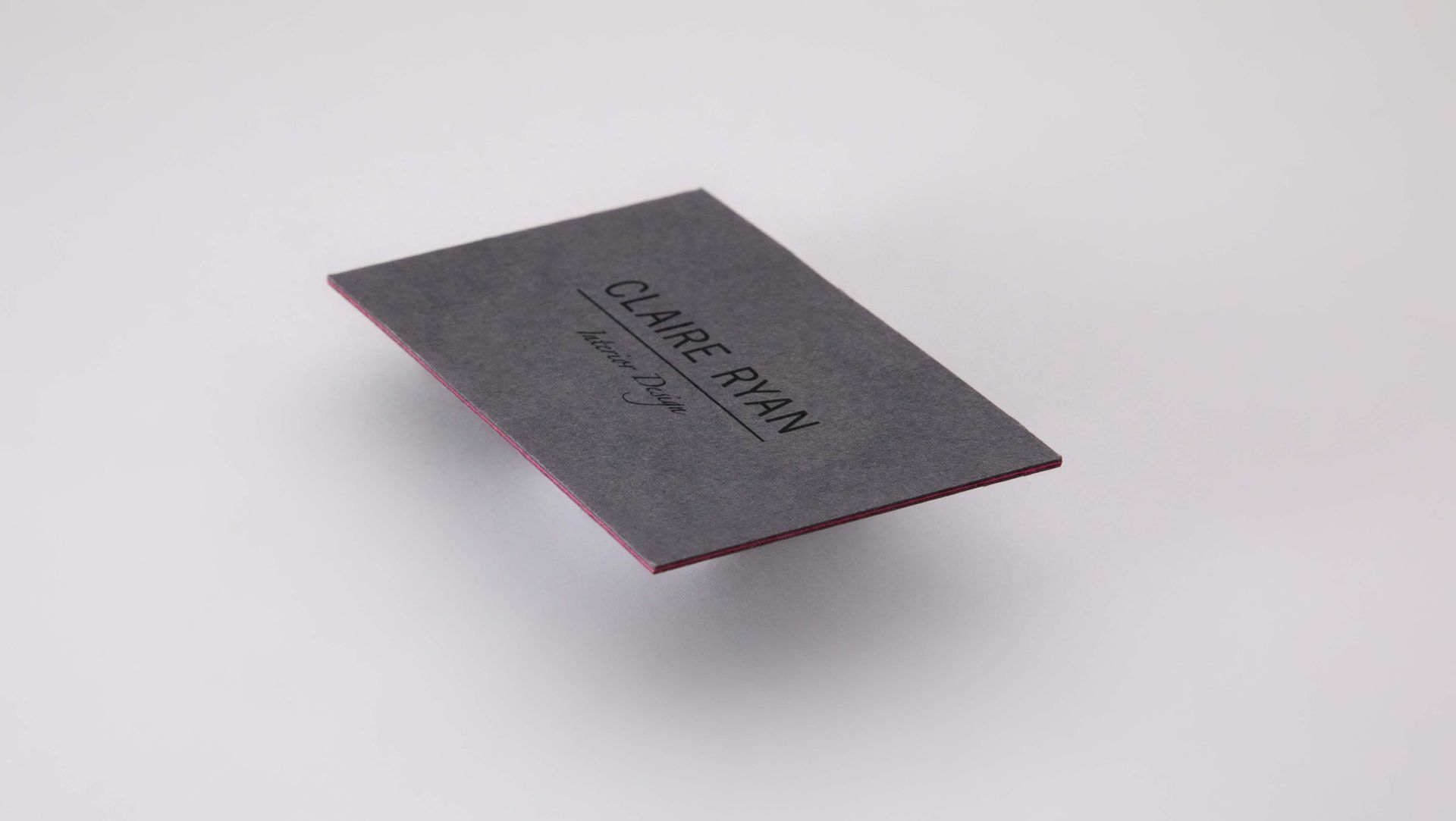 Gray business card with pink edges;