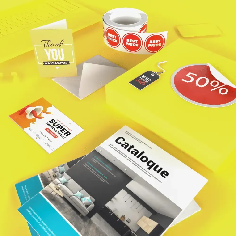 Promotional materials on a yellow surface: catalogs, stickers, cards, and an envelope.