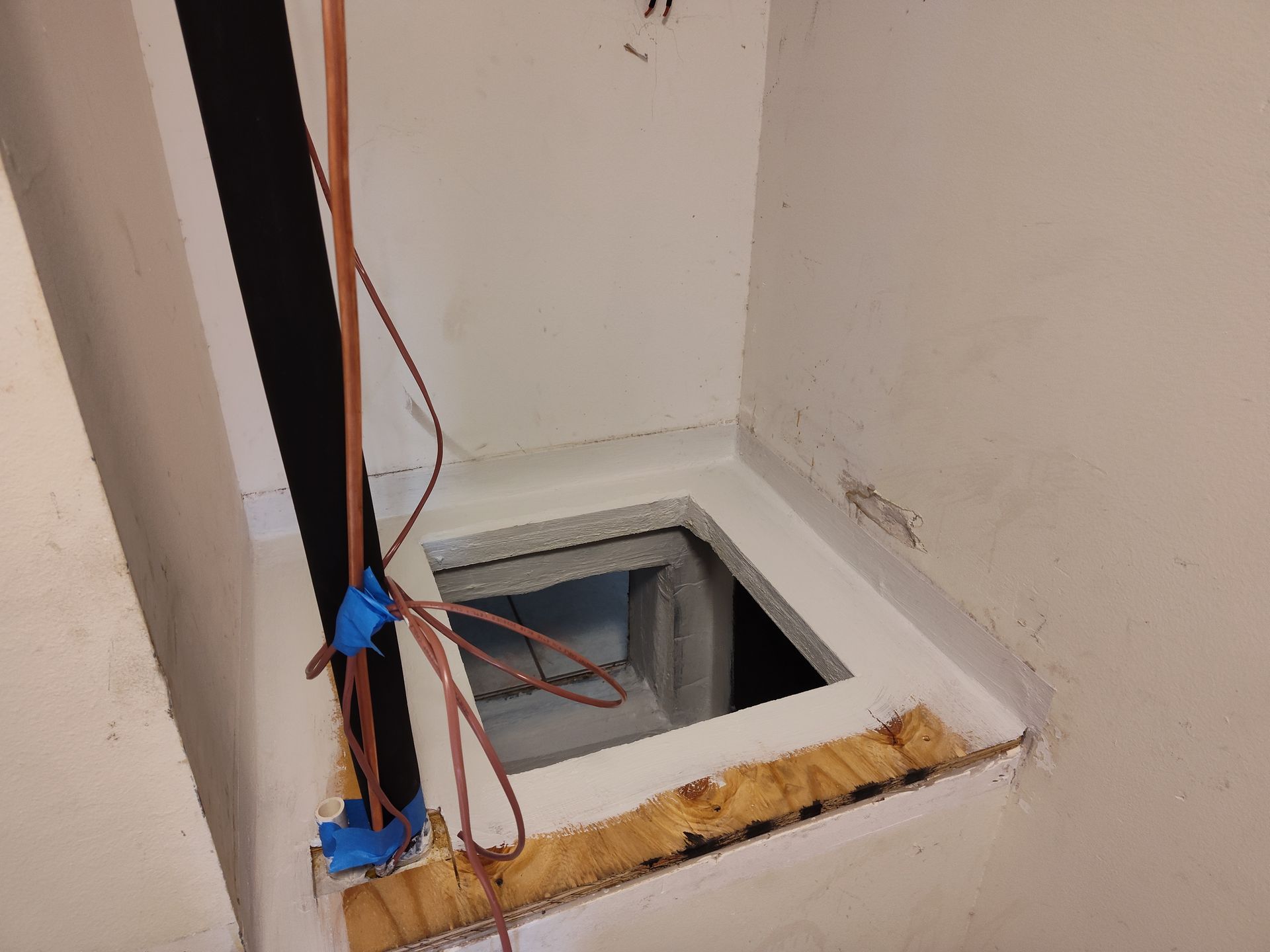 a hole in a wall with a pipe coming out of it .