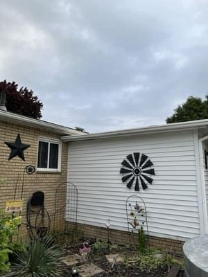Backyard patio with white siding, a black wall star, and a black-and-white windmill decoration