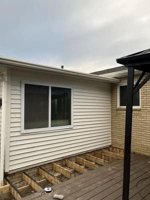 Backyard house exterior with a deck under construction and a sliding glass door
