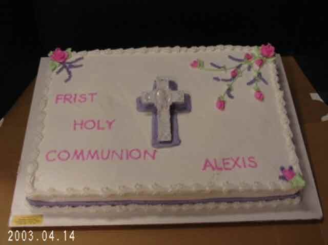 Cake decorated for First Holy Communion, white with purple cross and lettering, floral accents, name 