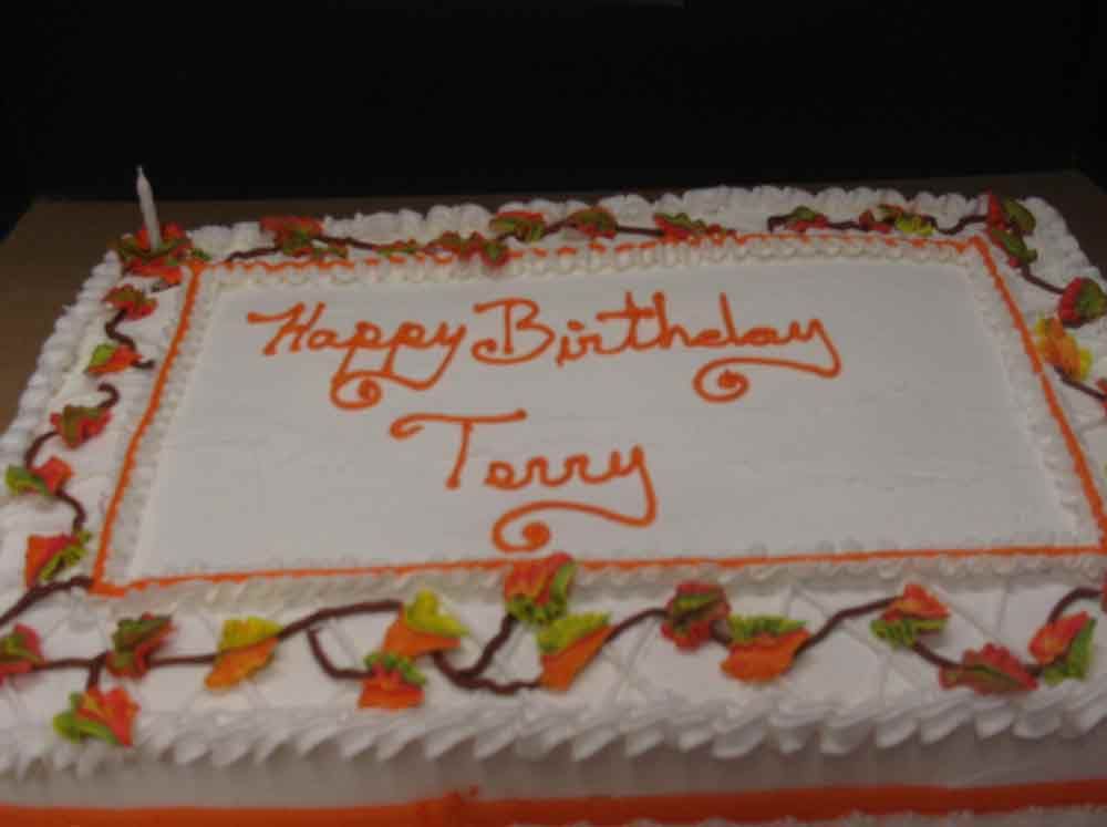White frosted sheet cake decorated with fall-colored leaves and 