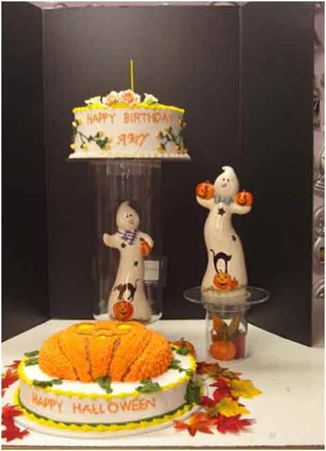 Halloween-themed birthday cakes with ghost figurines. 
