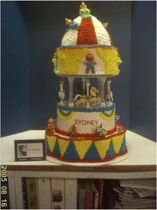 Carousel cake with yellow, red, and blue decorations. 